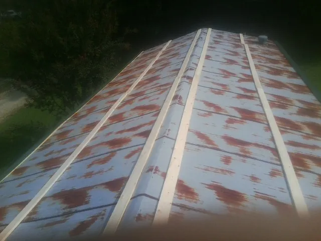 Rusted metal roof panels with new wood purlins before replacement — Storm Damage Roof Repair in Ooltewah by Roofing Brothers