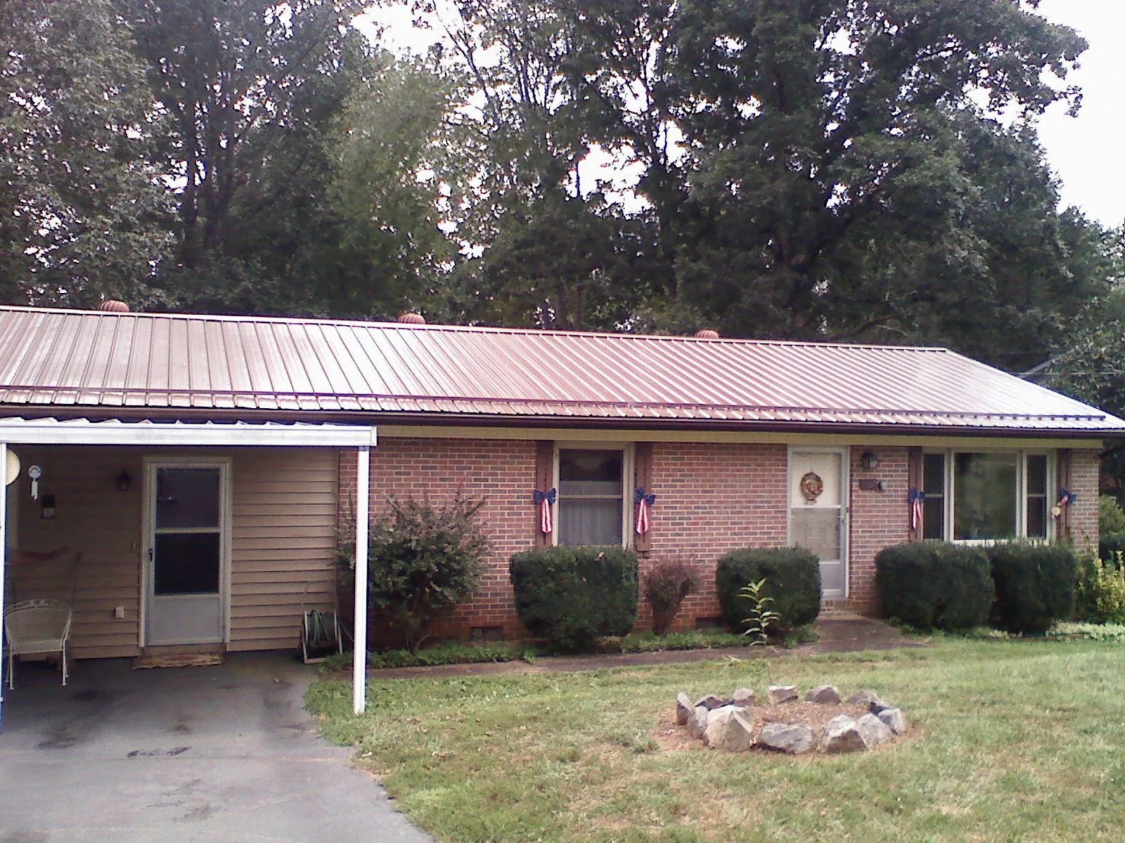 Bronze metal roof and carport on a brick ranch home — Roof Repair work by our crew in Ooltewah